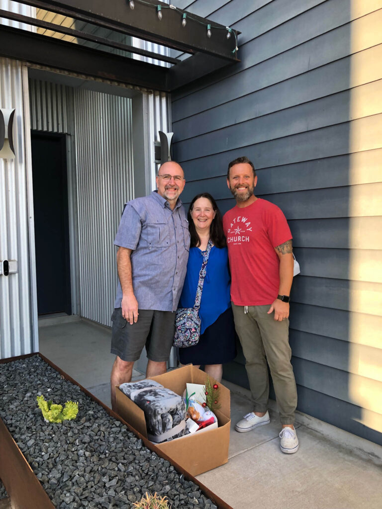Three people with a box of donations