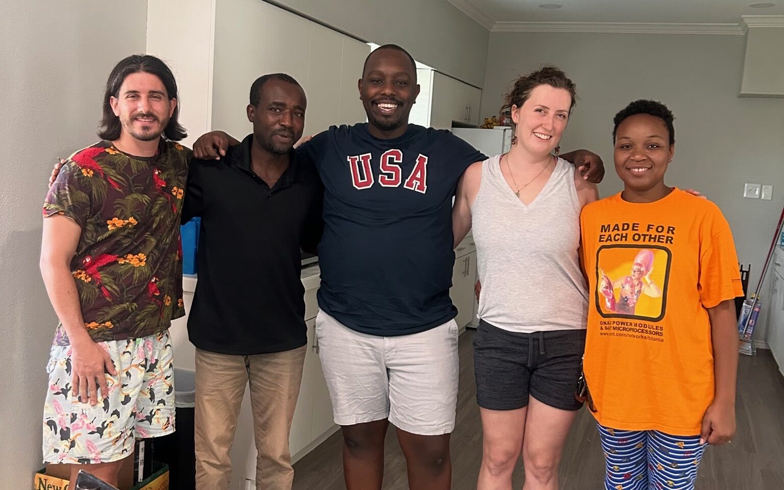 2 refugees wrapping arms with 3 volunteers