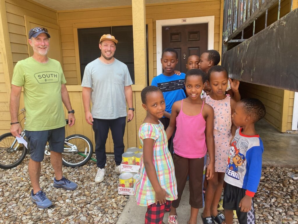 Refugee family outside with 2 volunteers